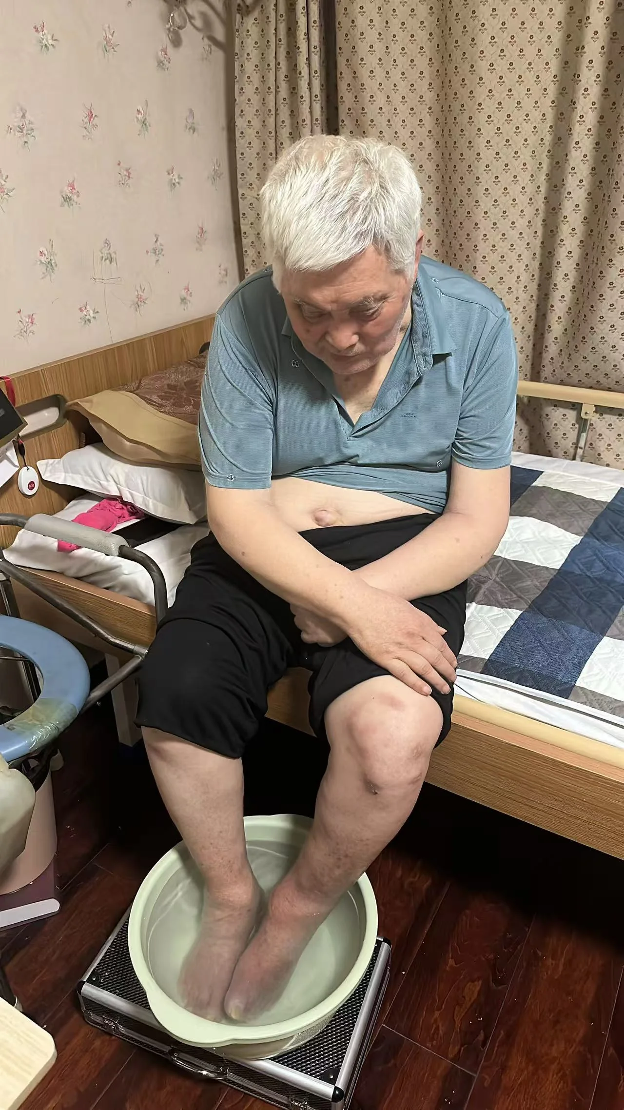 老人坐在床边泡脚