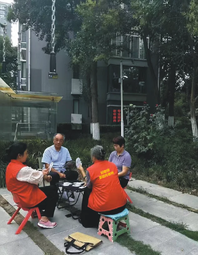 老人在小区花园打牌社交